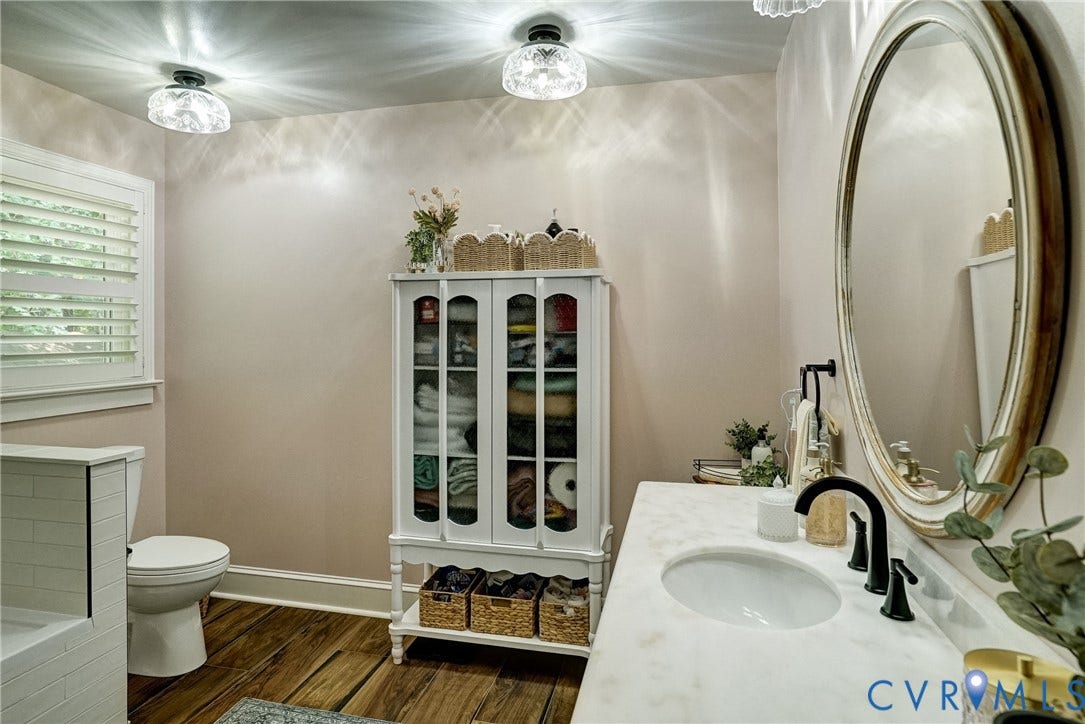 1174 Dorset Road, Powhatan, VA 23139 Bathroom featuring a single vanity with stone countertop and undermount sink, matte black faucet, and oval framed mirror