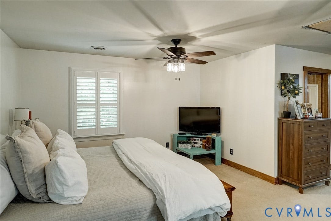 1174 Dorset Road, Powhatan, VA 23139 Bedroom featuring a ceiling fan with light fixture, plantation shutters, and wood-trim accents