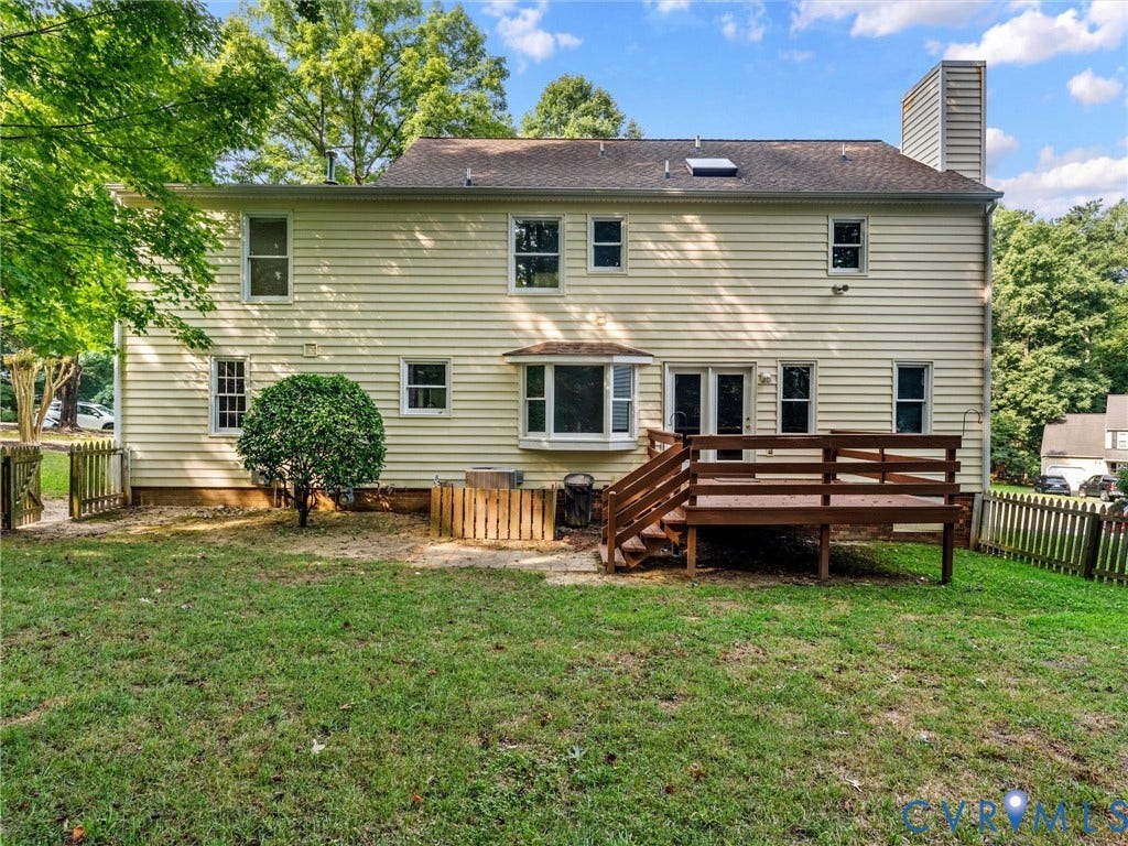 Rear exterior featuring a spacious wood deck with a fenced-in backyard.