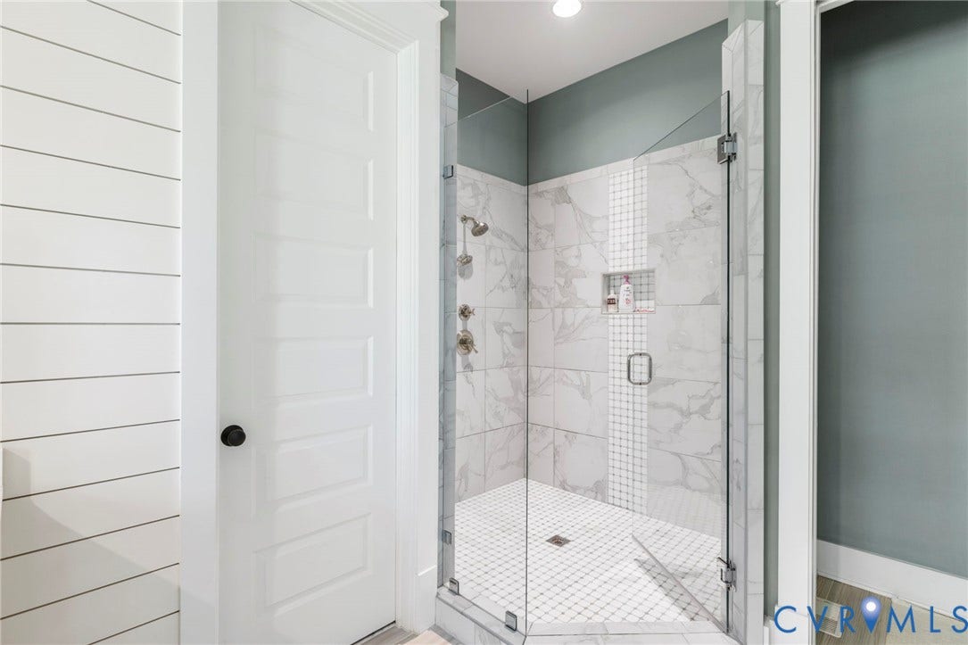1925 Muswell Court, Hallsley, Midlothian, VA 23112 Walk-in shower featuring a frameless glass enclosure, large format marble-look tile, decorative accent tile, built-in shower niche, and mosaic tile shower floor