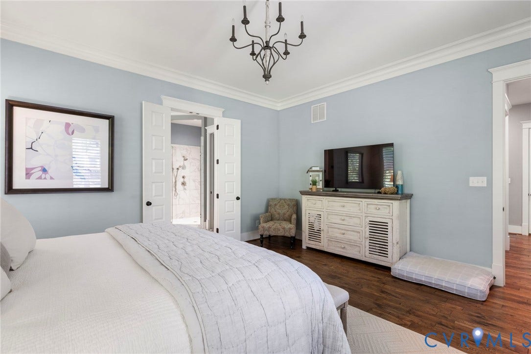 1925 Muswell Court, Hallsley, Midlothian, VA 23112 Spacious room featuring wood-finish flooring, a decorative ceiling fixture, crown molding, and double doors leading to a tiled shower