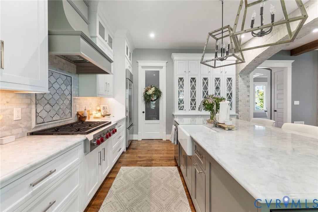 1925 Muswell Court, Hallsley, Midlothian, VA 23112 Gourmet kitchen featuring a substantial central island with a farmhouse sink, white perimeter cabinetry, professional-grade range, tiled backsplash, and wood-finish flooring
