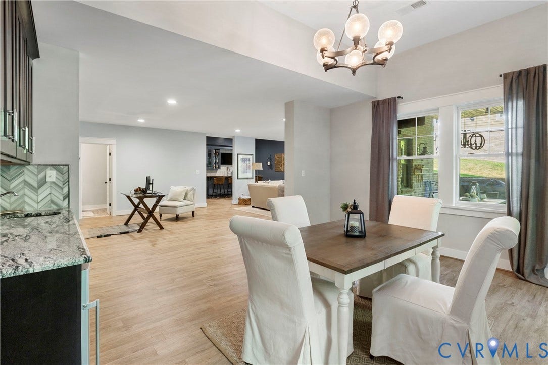 1925 Muswell Court, Hallsley, Midlothian, VA 23112 Dining area featuring a wood-finish table with light-colored chairs, an overhead chandelier with glass globes, and large windows with gray drapes