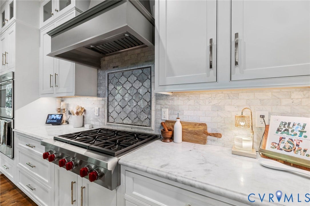 1925 Muswell Court, Hallsley, Midlothian, VA 23112 Stainless steel professional-grade gas range with distinctive red knobs beneath a custom range hood