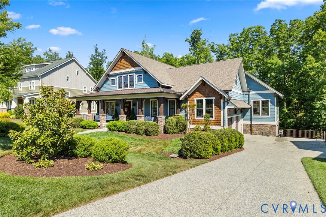 1925 Muswell Court, Hallsley, Midlothian, VA 23112 Craftsman-style exterior featuring blue siding, cedar shake accents, a covered front porch with stone pillars, an attached garage, and a concrete driveway