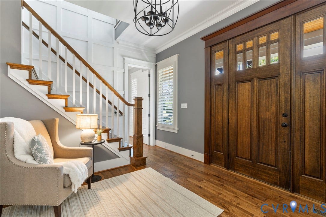 1925 Muswell Court, Hallsley, Midlothian, VA 23112 Entryway featuring rich wood-finish flooring, a grand staircase with white risers and wood-finish treads, a substantial wood-finish front door with transom windows, and wainscoting detail