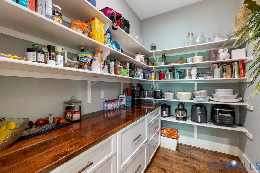 1925 Muswell Court, Hallsley, Midlothian, VA 23112 Spacious pantry featuring extensive shelving, a wood-finish countertop, white cabinetry with silver hardware, and wood-finish flooring