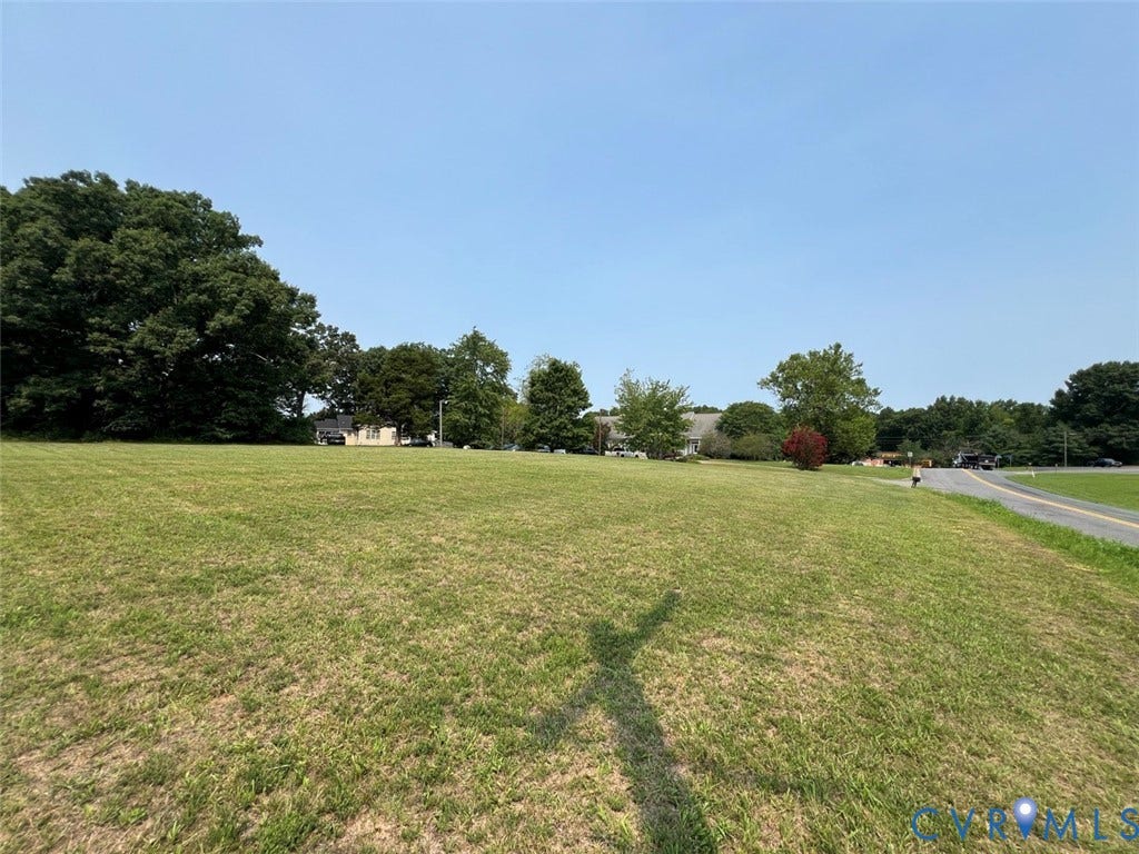 4064 James Madison Highway, Fork Union, VA 23055 Expansive green space featuring a large grassy area, mature trees, and a paved road