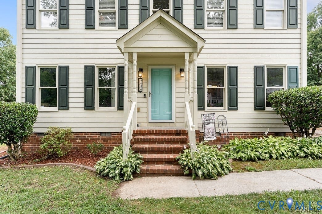 8436 Sir Lionel Place, Kingsland Wood, Ampthill, VA 23237 Two-story residence featuring light-toned siding, dark shutters, and a brick foundation