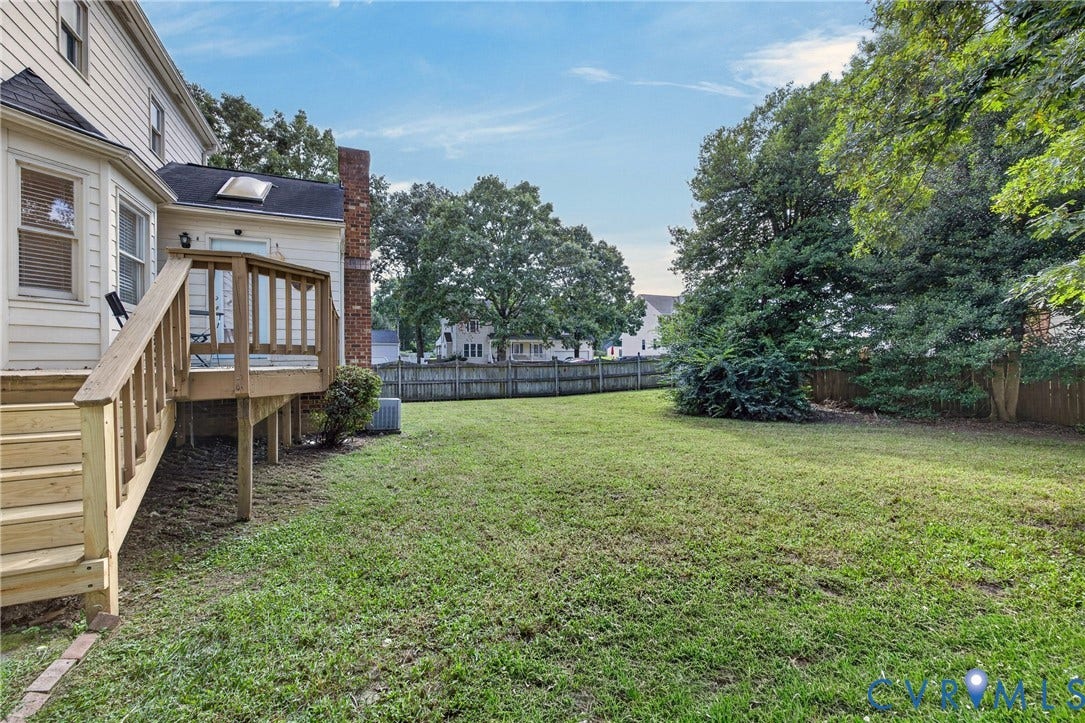8436 Sir Lionel Place, Kingsland Wood, Ampthill, VA 23237 Expansive backyard with a wooden fence, mature trees, and a multi-level wooden deck with stairs