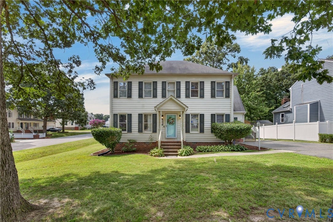 8436 Sir Lionel Place, Kingsland Wood, Ampthill, VA 23237 Two-story colonial-style residence featuring white siding, dark shutters, and a welcoming light blue front door