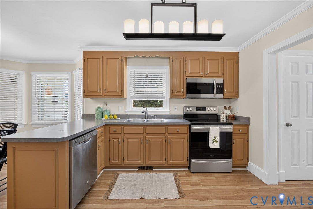 8436 Sir Lionel Place, Kingsland Wood, Ampthill, VA 23237 Wood-finish flooring, stainless steel appliances, upper and lower cabinetry, an eat-at counter, and a contemporary chandelier
