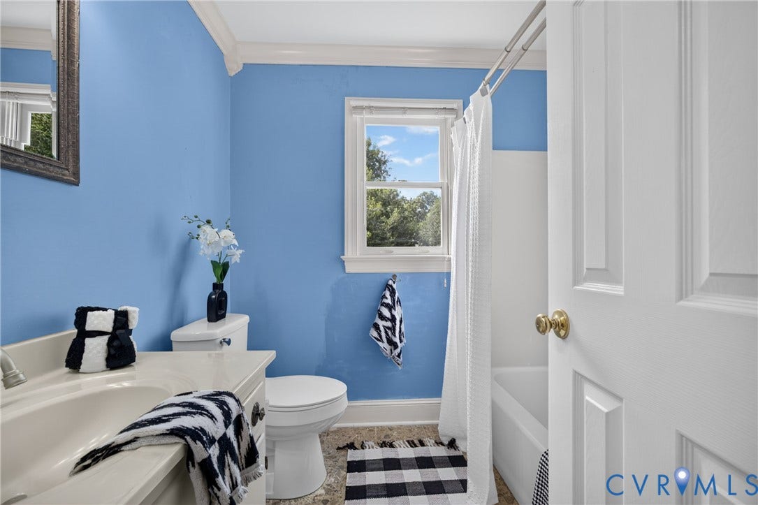 8436 Sir Lionel Place, Kingsland Wood, Ampthill, VA 23237 Bright bathroom featuring periwinkle-painted walls, white subway tile wainscoting, and a white ceramic pedestal sink