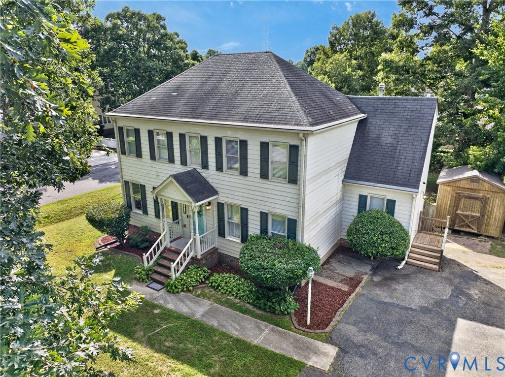 8436 Sir Lionel Place, Kingsland Wood, Ampthill, VA 23237 Two-story residence with white siding, dark shutters, covered front porch, paved driveway, and detached storage shed