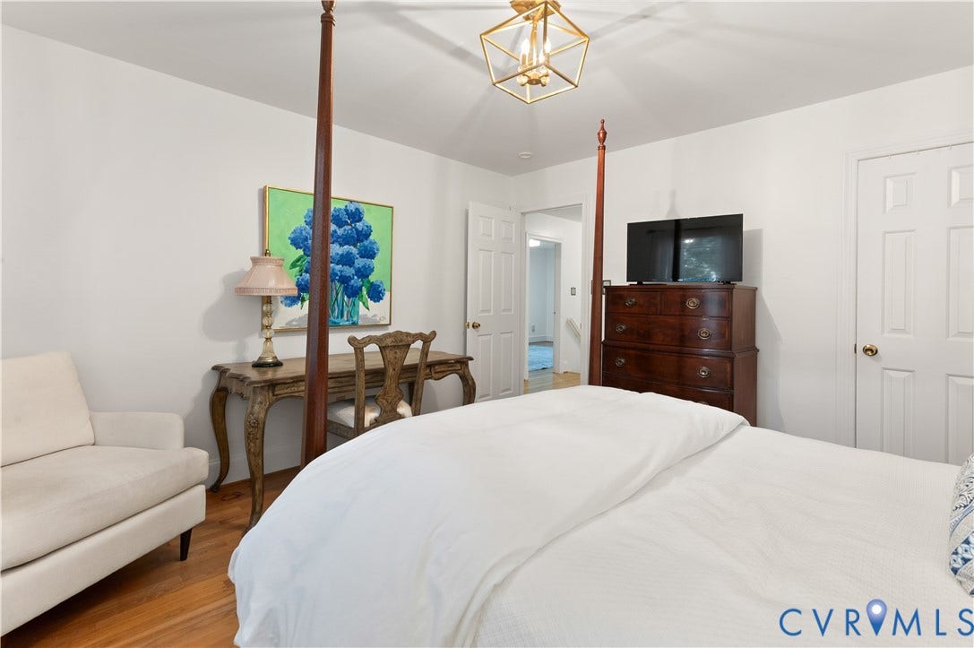 1905 Tunbridge Drive, Henrico, VA 23238 Spacious bedroom featuring warm wood-finish flooring, white walls, and a geometric brass light fixture