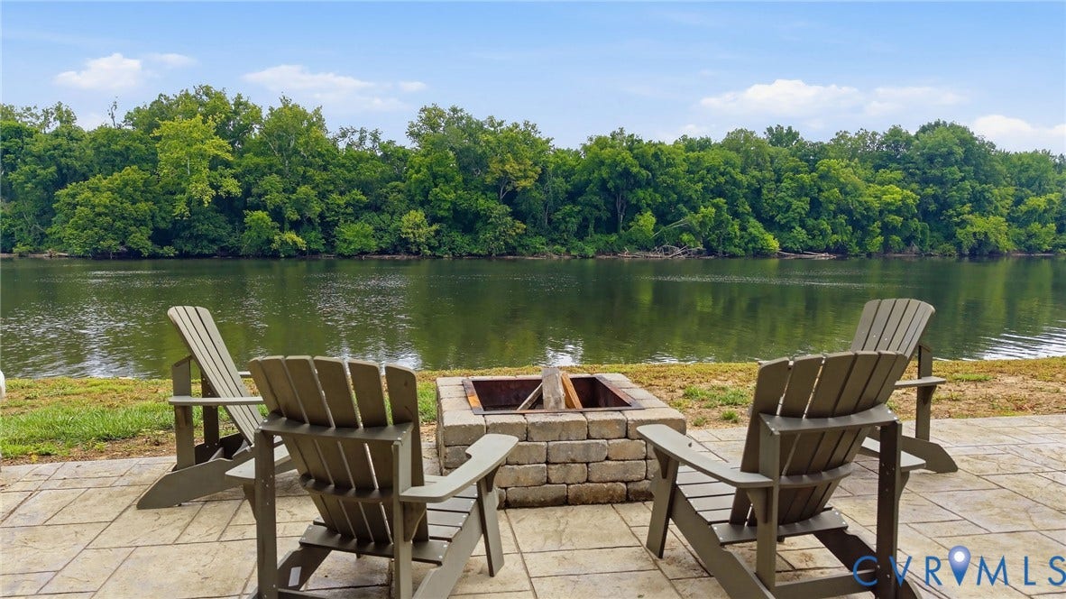 3655 Stone Harbor Drive, Midlothian, VA 23113 Paved patio featuring a built-in stone fire pit and immediate water frontage framed by mature trees