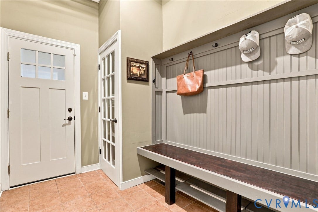 3655 Stone Harbor Drive, Midlothian, VA 23113 Built-in mudroom bench with dark wood-finish seating, beadboard paneling, and integrated coat hooks