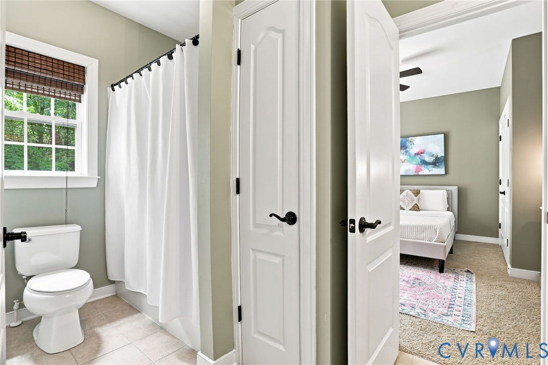 3655 Stone Harbor Drive, Midlothian, VA 23113 Bathroom featuring a window with a woven wood shade, a white toilet, and a shower with a white curtain