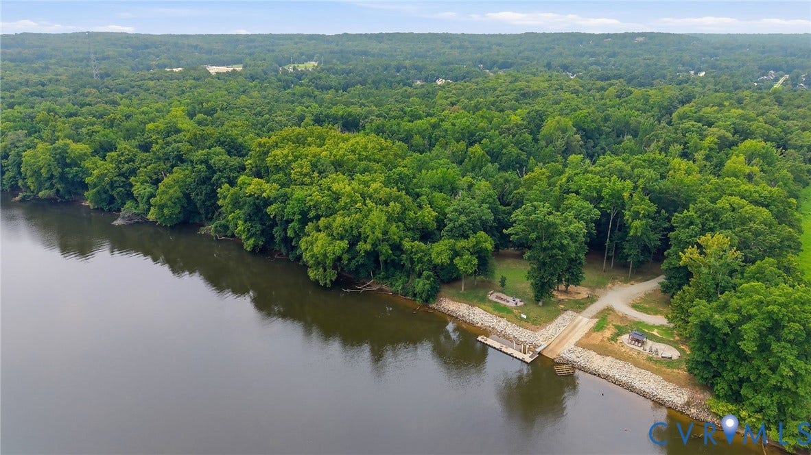 3655 Stone Harbor Drive, Midlothian, VA 23113 Waterfront property featuring extensive tree cover, a private boat dock, a boat launch, and a gravel access road