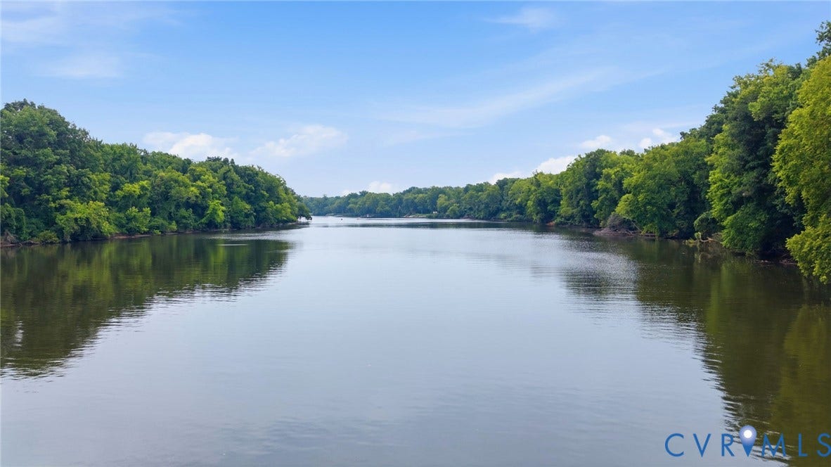 3655 Stone Harbor Drive, Midlothian, VA 23113 Expansive waterway bordered by mature deciduous trees on both banks, under a clear blue sky