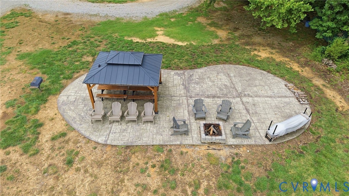 3655 Stone Harbor Drive, Midlothian, VA 23113 Expansive stamped concrete patio featuring a gazebo with a metal roof, a built-in fire pit, and ample open-air space