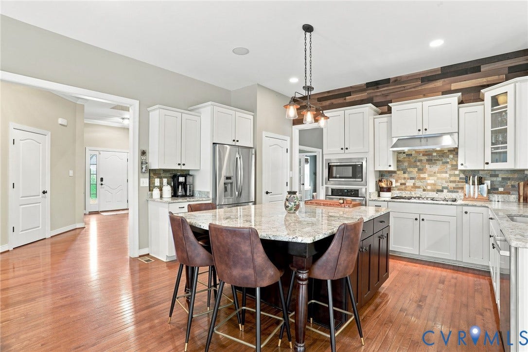 3655 Stone Harbor Drive, Midlothian, VA 23113 Kitchen featuring a central island with a granite countertop, white cabinetry, stainless steel appliances, and wood-finish flooring