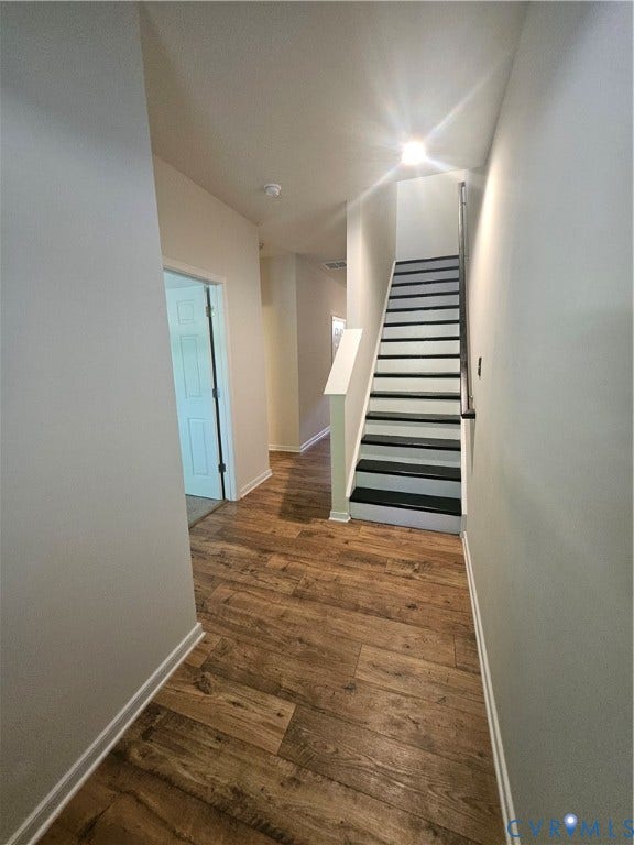 11304 Magill Terrace Drive, Chester, VA 23831 Hallway featuring wood-finish flooring, light-colored walls, and a staircase with dark treads and a light railing