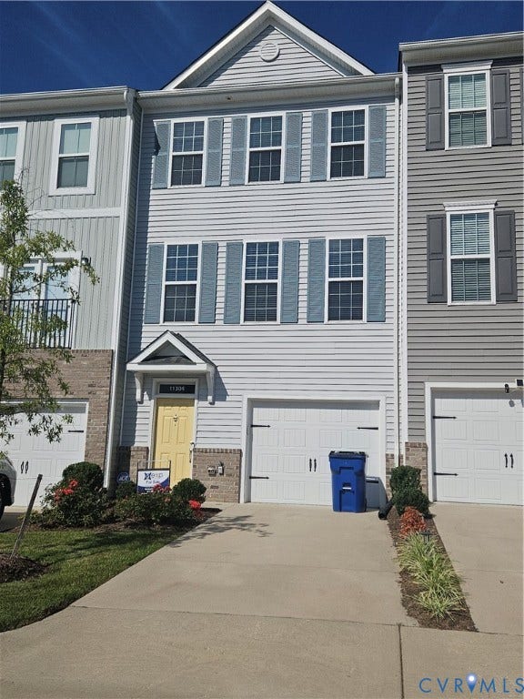 11304 Magill Terrace Drive, Chester, VA 23831 Two-story facade with light-colored siding, white garage door, and a yellow entry door