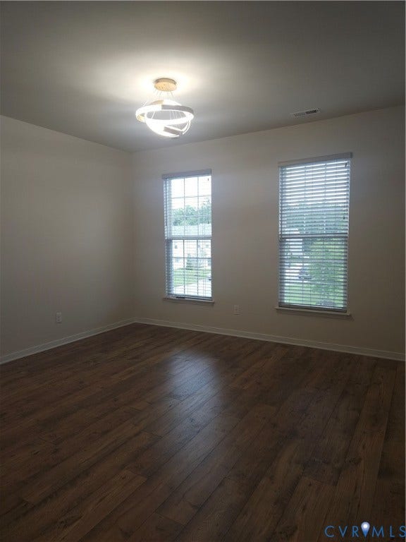 11304 Magill Terrace Drive, Chester, VA 23831 Room featuring wood-finish flooring, two windows with blinds, a ceiling-mounted light fixture, and neutral wall paint