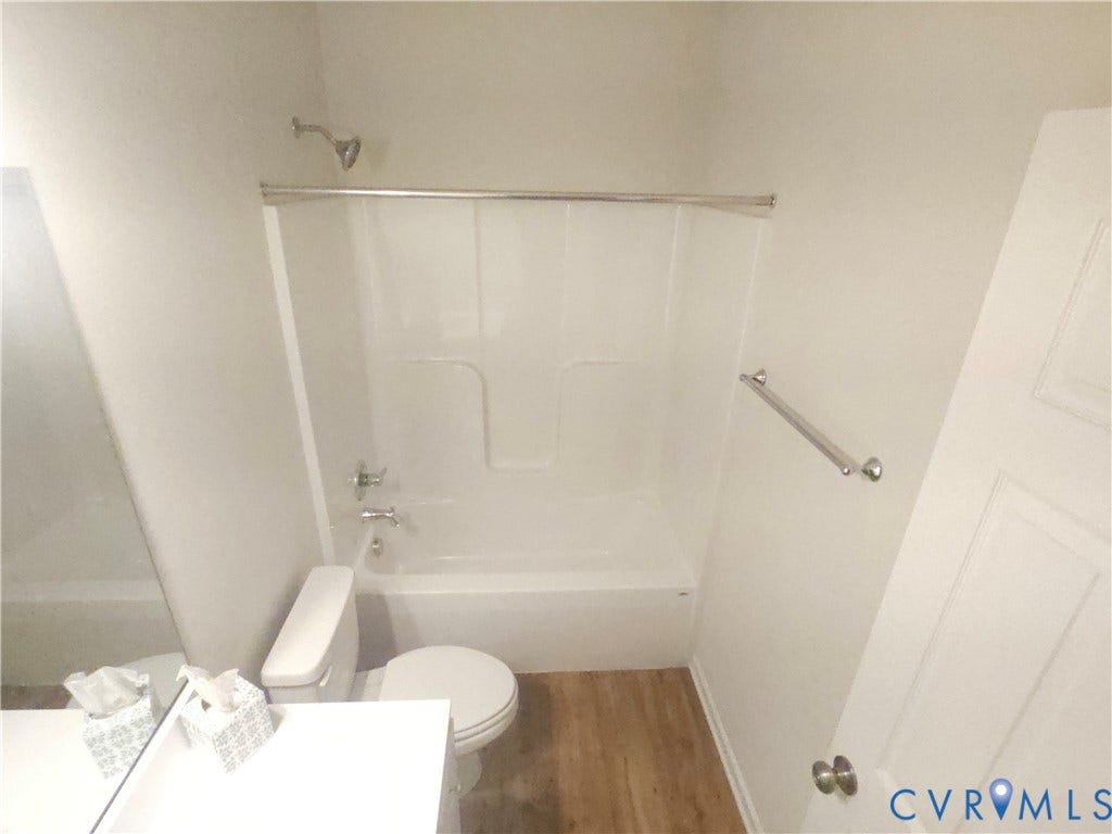 11304 Magill Terrace Drive, Chester, VA 23831 White bathtub with integrated shower, chrome fixtures, and wood-finish flooring