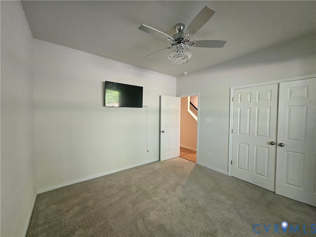 11304 Magill Terrace Drive, Chester, VA 23831 Spacious bedroom featuring neutral carpeting, dual closets with six-panel doors, ceiling fan with integrated lighting fixture, and a window with natural light