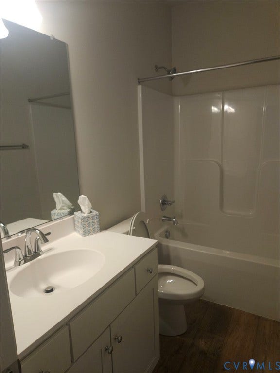 11304 Magill Terrace Drive, Chester, VA 23831 Bathroom featuring a white vanity with integrated sink, chrome fixtures, a full-width mirror, and wood-finish flooring