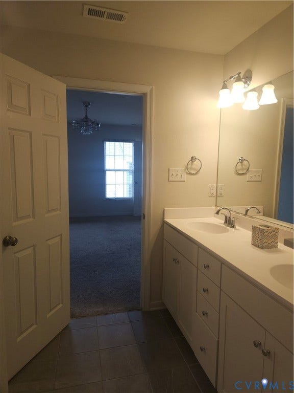 11304 Magill Terrace Drive, Chester, VA 23831 Bathroom vanity with double sinks, chrome fixtures, and a large wall-mounted mirror