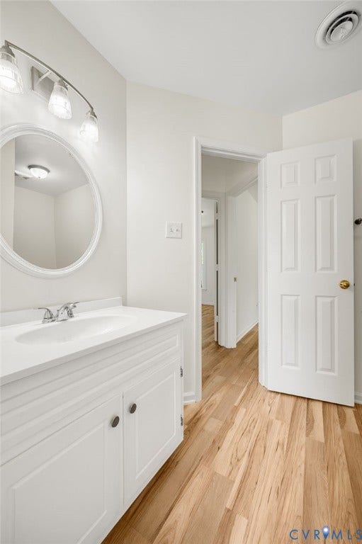 1723 Porter Street, Richmond, VA 23224 Bright bathroom featuring a white vanity with integrated sink, chrome faucet, and a large oval mirror