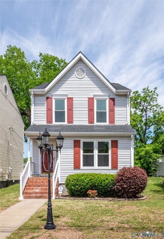 1723 Porter Street, Richmond, VA 23224 Two-story residence featuring light-colored siding, a dark roof, and red window shutters