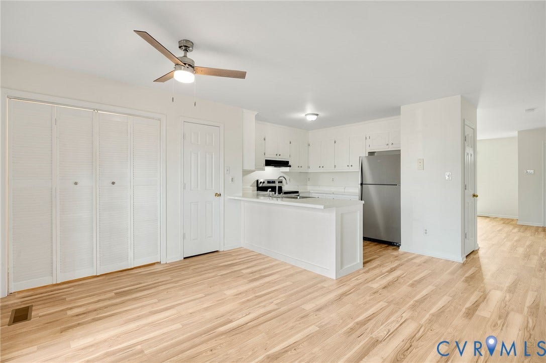 1723 Porter Street, Richmond, VA 23224 Open-concept living area featuring light wood-finish flooring, white walls, and a ceiling fan with integrated lighting