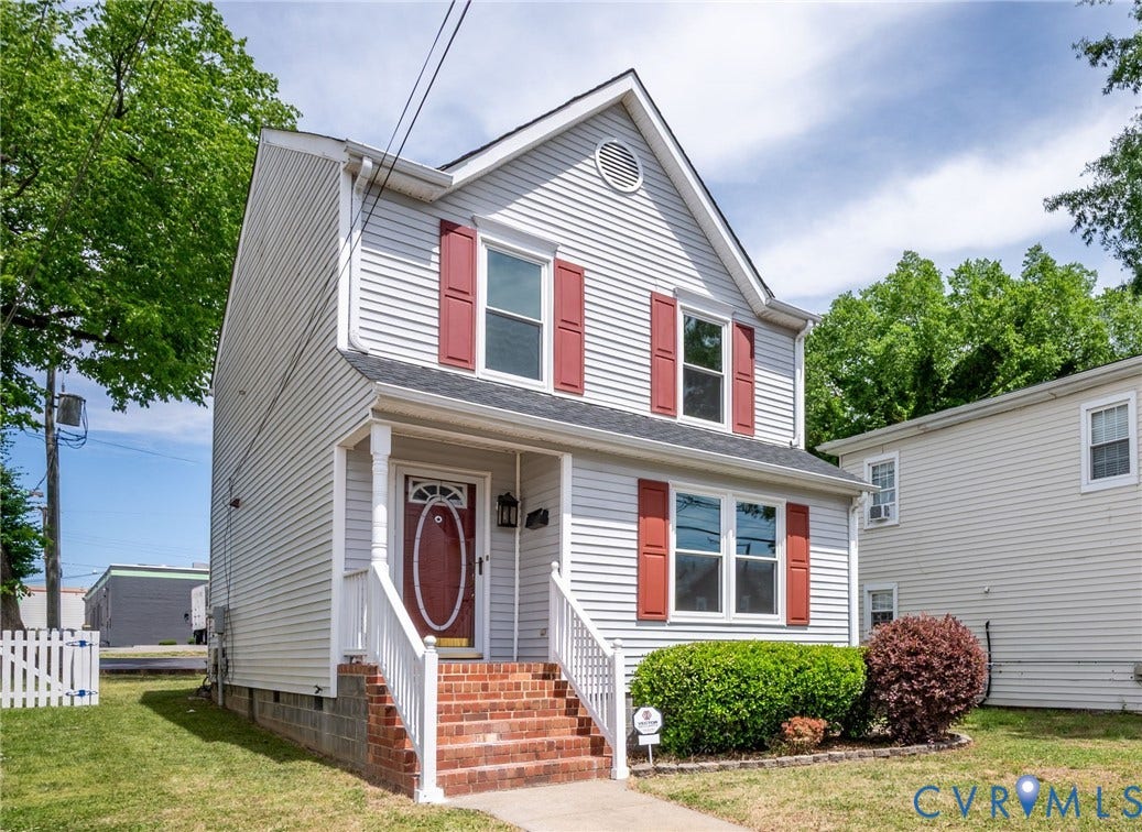 1723 Porter Street, Richmond, VA 23224 Two-story residence featuring light-toned siding, red decorative shutters, and a prominent front entry with a red door