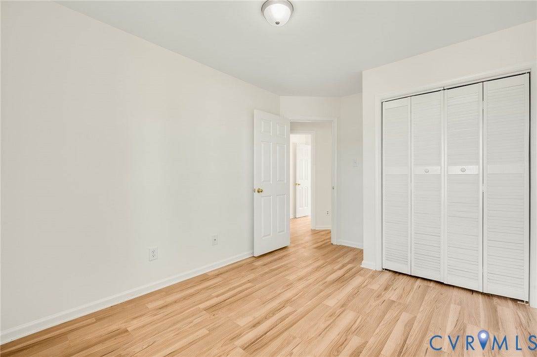 1723 Porter Street, Richmond, VA 23224 Room featuring light wood-finish flooring, white walls, and a louvered bi-fold closet