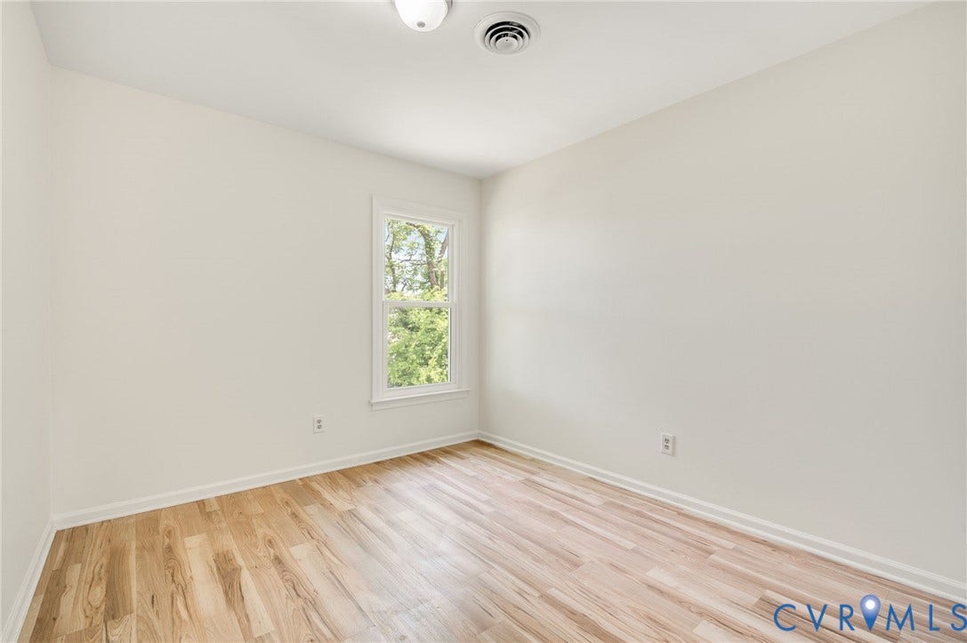1723 Porter Street, Richmond, VA 23224 Room featuring wood-finish flooring, white baseboards, and a window with white trim