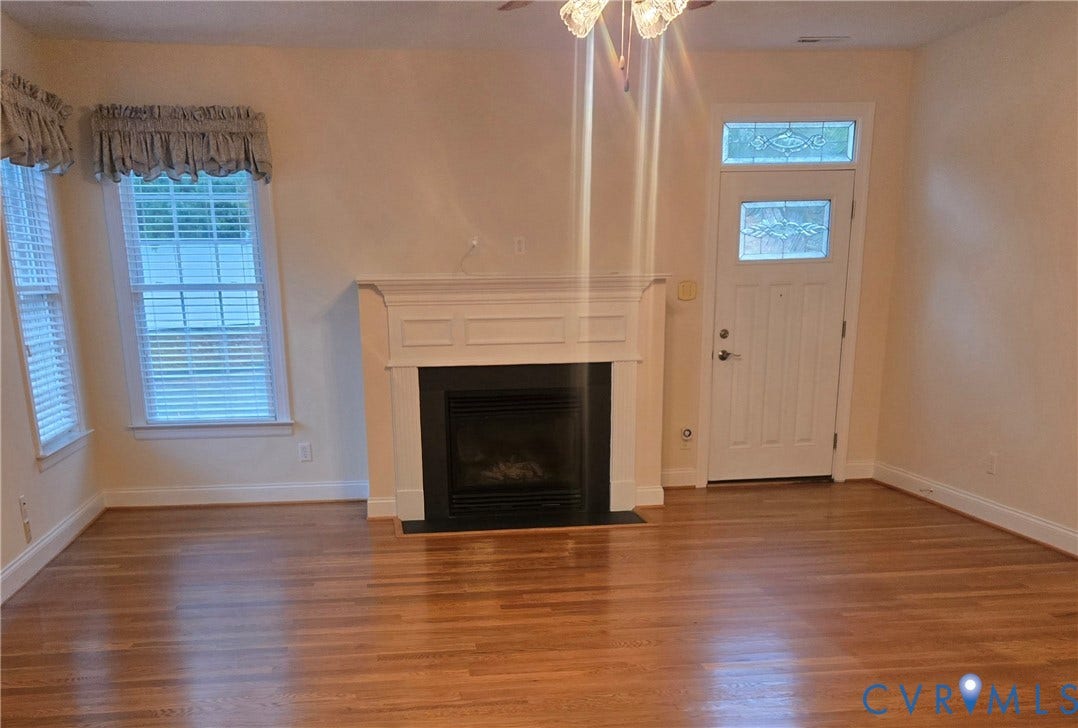 4401 Village Garden Circle, Chester, VA 23831 wood engineered flooring, a white natural gas vented fireplace mantel fireplace with a black surround, and multiple windows with white blinds