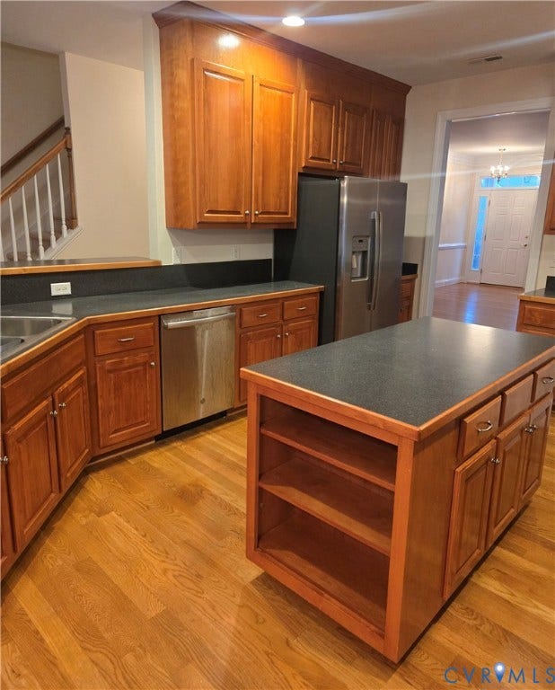 4401 Village Garden Circle, Chester, VA 23831 Kitchen featuring wood engineered flooring, a central island with integrated shelving, dark countertops, and stainless steel appliances
