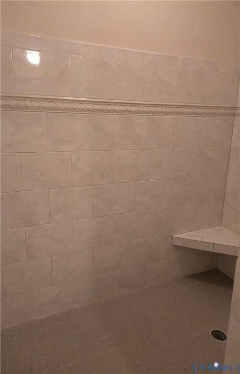 4401 Village Garden Circle, Chester, VA 23831 Ceramic tile large shower, decorative pattern, a built-in corner bench, and matching rectangular floor tiles