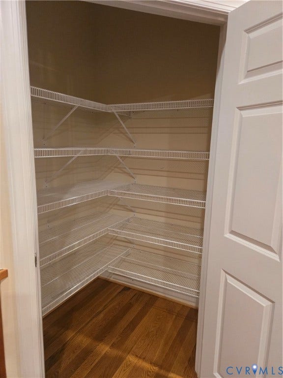 4401 Village Garden Circle, Chester, VA 23831 Built-in wire shelving system, extending along two walls, with wood-finish flooring and a paneled interior door