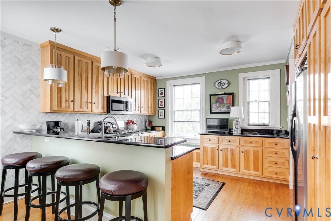 3006 Monument Avenue, #U2W, Museum District, Richmond, VA 23221 Kitchen with natural wood cabinetry, black countertops, and a herringbone-patterned tile backsplash