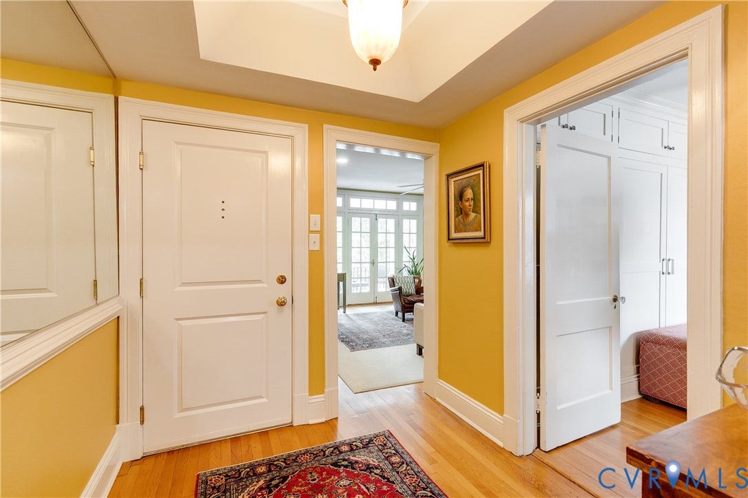 3006 Monument Avenue, #U2W, Museum District, Richmond, VA 23221 Entryway featuring wood-finish flooring, a white paneled door, and a built-in overhead light fixture