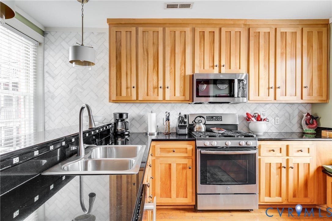 3006 Monument Avenue, #U2W, Museum District, Richmond, VA 23221 Kitchen featuring natural wood cabinetry, dark countertops, a stainless steel gas range, an over-the-range microwave, and a double basin stainless steel sink with a high-arc faucet