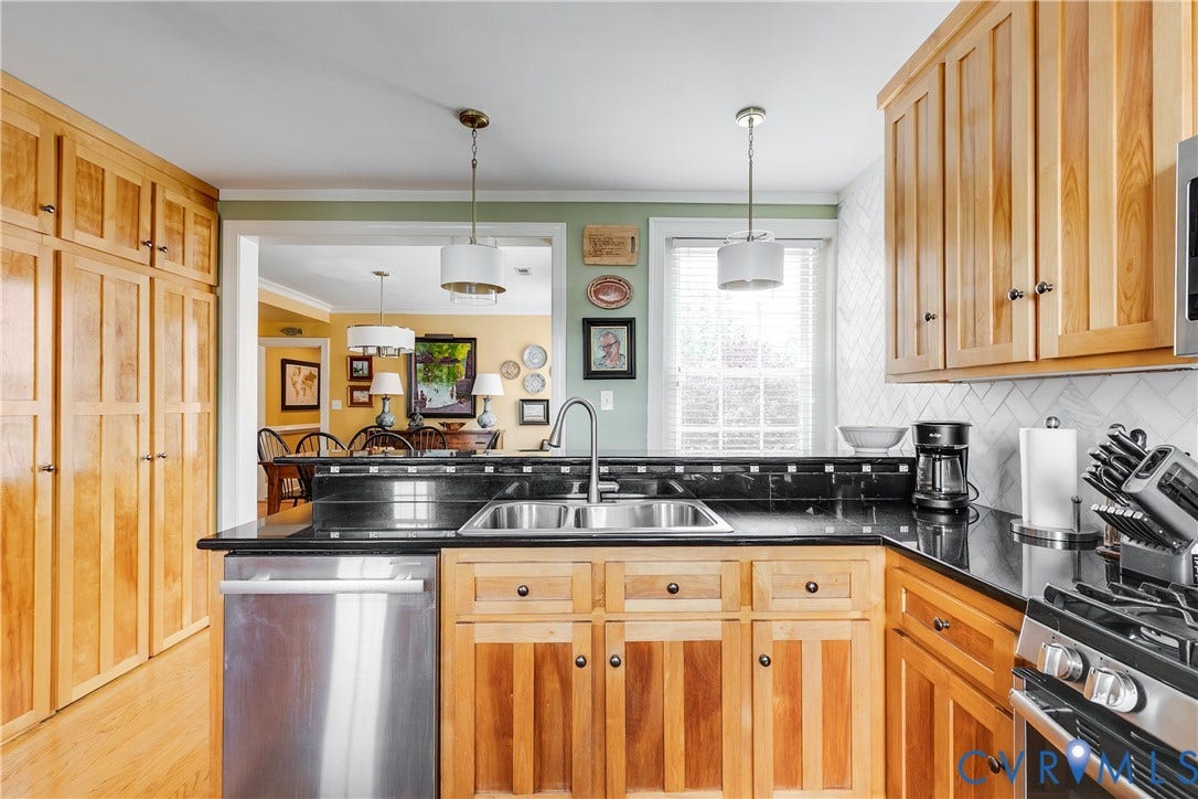 3006 Monument Avenue, #U2W, Museum District, Richmond, VA 23221 Kitchen featuring wood cabinetry, stainless steel appliances, black countertops, and a subway tile backsplash