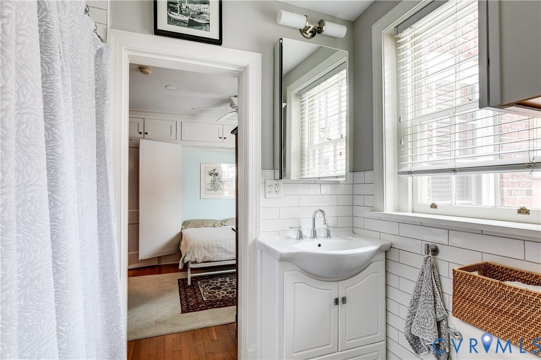 3006 Monument Avenue, #U2W, Museum District, Richmond, VA 23221 Bathroom featuring a white subway tile surround, single window with blinds, and a vanity with an integrated sink
