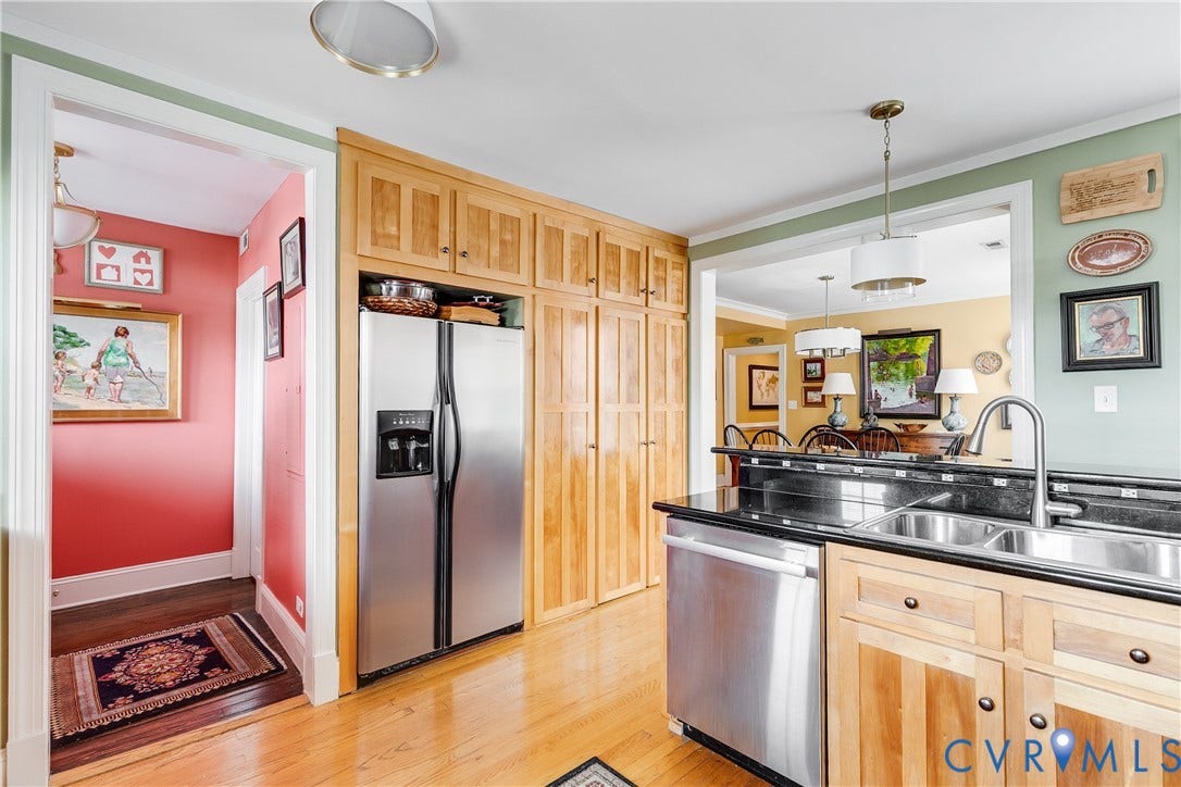 3006 Monument Avenue, #U2W, Museum District, Richmond, VA 23221 Kitchen featuring wood-finish flooring, stainless steel appliances, black countertops, wood cabinetry, and a double basin sink with a gooseneck faucet