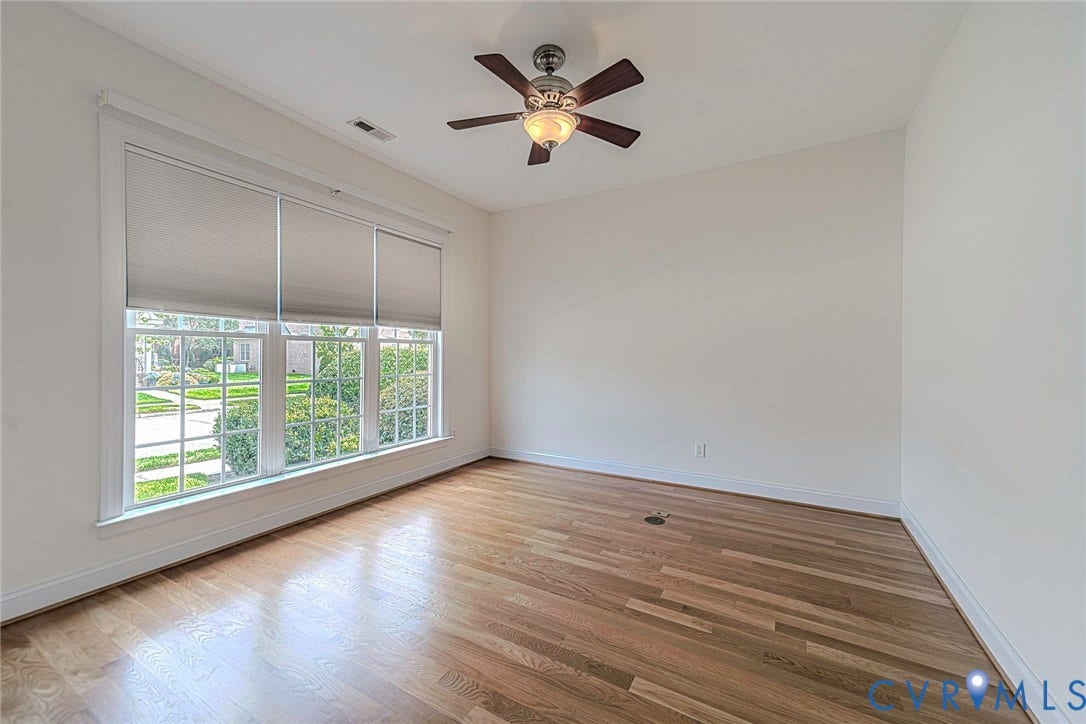 4309 Village Creek Drive, Chester, VA 23831 Spacious room featuring wood-finish flooring, a multi-pane window with custom shades, and a ceiling fan with integrated lighting, living room/flex room or office. The french doors are in the attic.